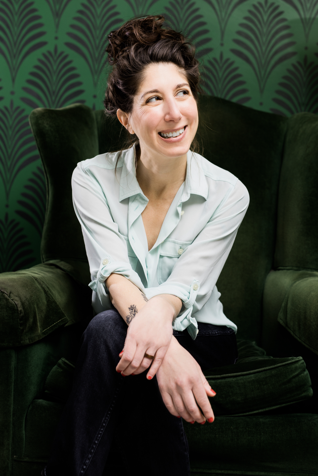 Ann Tropea smiling in a green chair